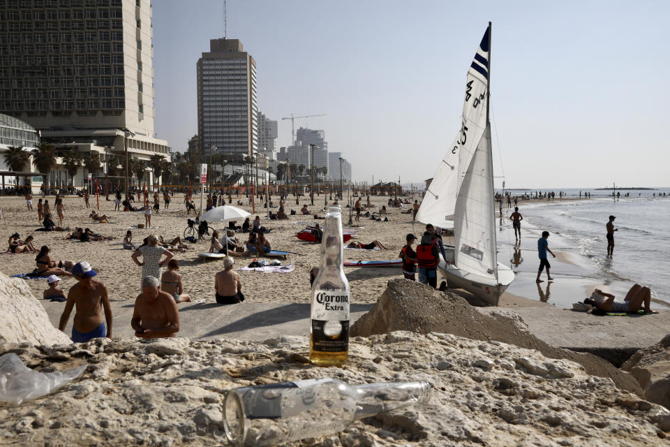 Israelis enjoy the beach in Tel Aviv, Israel, Monday, March 16, 2020. Israel imposed sweeping travel and quarantine measures the government ordered restaurants, malls, cinemas, gyms and daycare centers shut to containt the spread of the coronovisrus. (AP Photo/Oded Balilty)