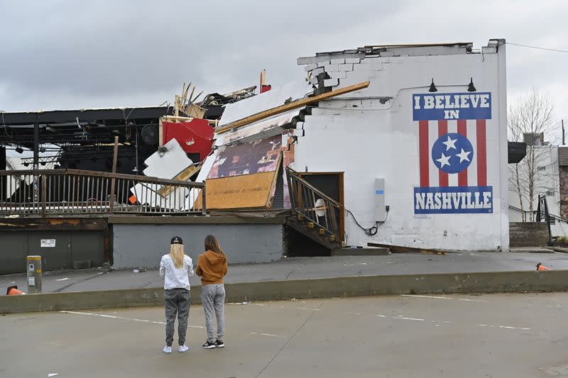 Women view damage at the Basement East music venue after a tornado touched down in Nashville