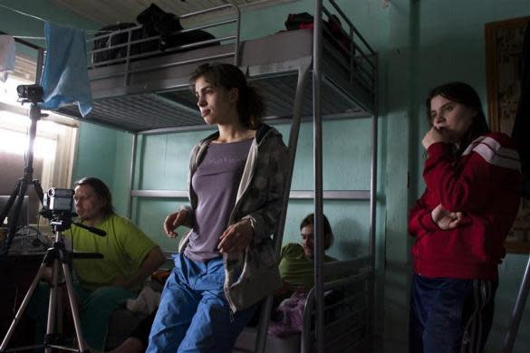 Political activists Yekaterina Samutsevich (R) Pyotr Verzilov (2nd R) and his wife Nadezhda Tolokonnikova attend the birth of Oleg Vorotnikov (L) and Natalia Sokol's first child Kasper in a secret hideout in Moscow, June 19, 2009. Tolokonnikova later became a member of Pussy Riot.