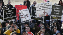 Abortion opponents try to block Abortion rights advocates at a rally on the steps of the Kansas Statehouse in Topeka, Kan., Tuesday, Jan. 22, 2013. Gov. Sam Brownback has signed a series of tough, anti-abortion measures during his first two years in office. Much to the dismay of abortion-rights advocates, Kansas has been part of a wave in which states with Republican governors and GOP-controlled Legislatures enacted new restrictions on abortion providers. (AP Photo/Orlin Wagner)