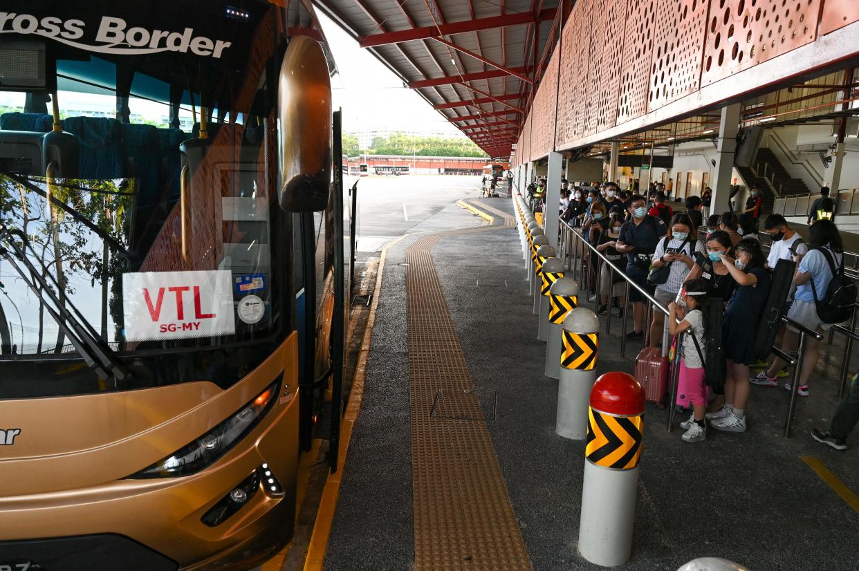 People wait to board a bus under the vaccinated travel lane (VTL) for border-crossing passengers between Singapore and Malaysia.