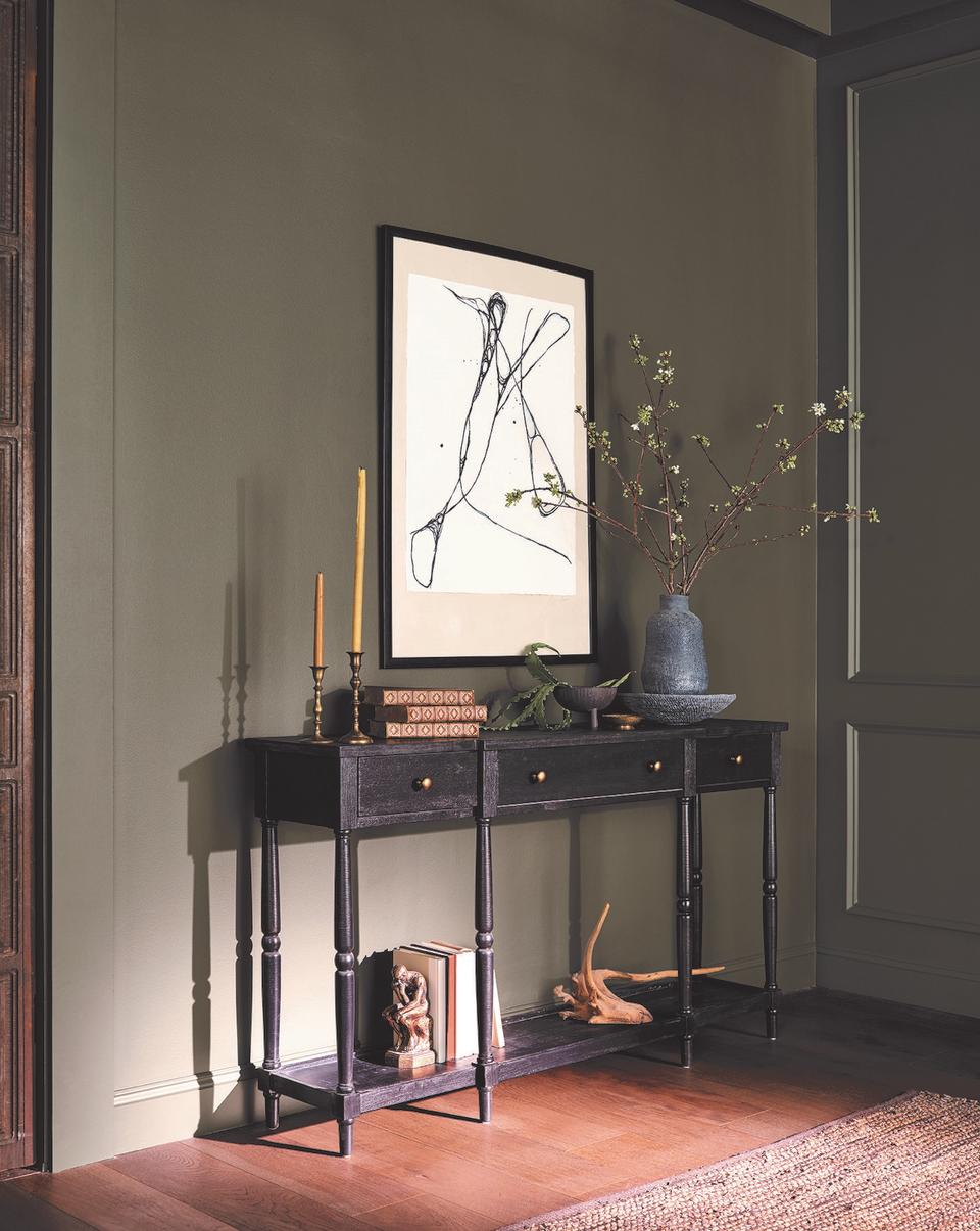 Olive green entryway with black accessorized console table.
