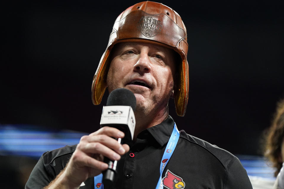 Louisville head coach Jeff Brohm stands on a stage near the Old Leather Helmet trophy after an NCAA college football game against Georgia Tech, Friday, Sept. 1, 2023, in Atlanta. Louisville won 39-34. (AP Photo/Mike Stewart)