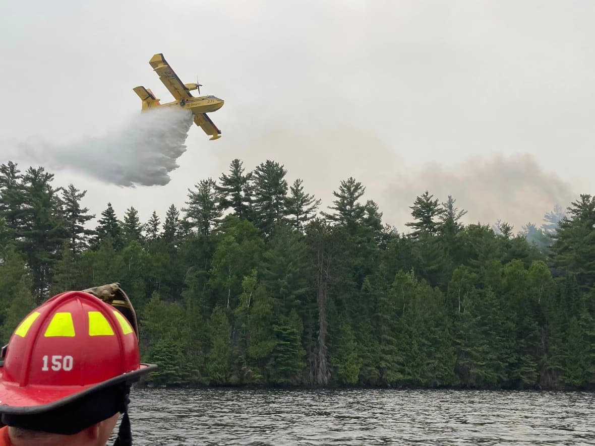 A water bomber drops water on a fire near Centennial Lake in the Township of Greater Madawaska, Ont., west of Ottawa. (South Frontenac Fire & Rescue/Facebook - image credit)