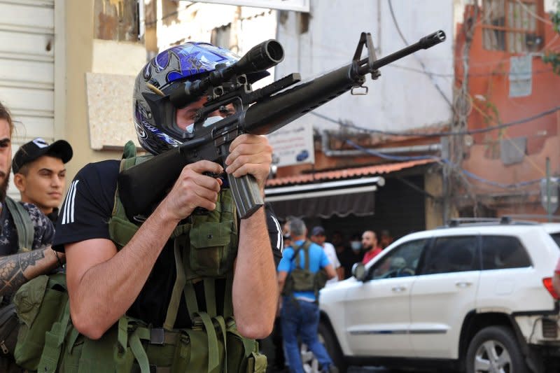 Shiite fighter from Hezbollah and Amal movements takes aim with a Kalashnikov assault rifle amidst clashes in the area of Tayouneh, Beirut, Oct. 14, 2021. File Photo by Jamal Eddine/ UPI