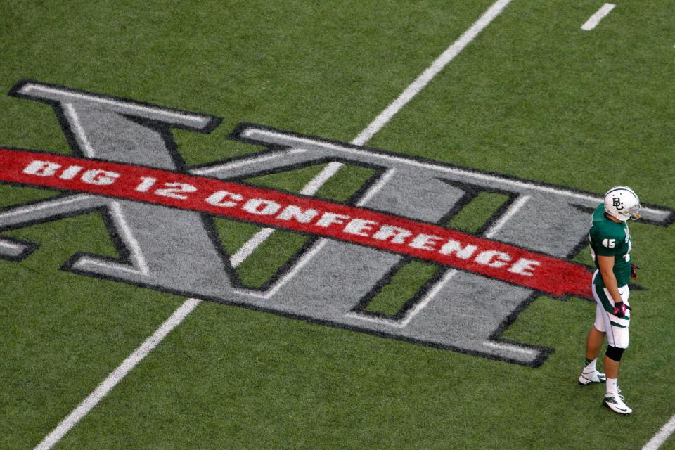 FILE - In this Oct. 13, 2012, file photo, Baylor's Matt Ritchey (45) stands on the field by a Big 12 Conference logo during an NCAA college football game against TCU in Waco, Texas. Big 12 commissioner Bob Bowlsby feels good about where the league is with nine teams getting ready to play season openers this week. But the game not being played provides a stark reminder of the uncertainty of playing amid COVID-19. TCU won't be on the field because of a virus outbreak on its campus.