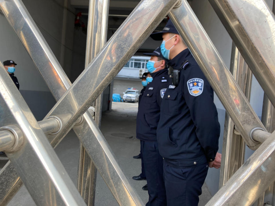 Security officers stand in formation near a court building in Dandong in northeastern China's Liaoning Province, Friday, March 19, 2021. China was expected to open the first trial Friday for Michael Spavor, one of two Canadians who have been held for more than two years in apparent retaliation for Canada's arrest of a senior Chinese telecom executive. (AP Photo/Ken Moritsugu)