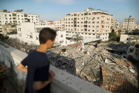 A Palestinian boy looks at the remains of a building that was destroyed in Israeli air strikes, in Gaza City May 5, 2019. REUTERS/Suhaib Salem