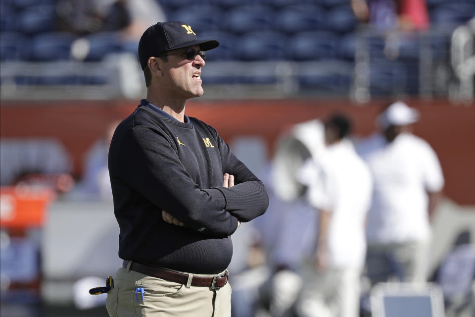 Michigan head coach Jim Harbaugh watches players warm up before the Citrus Bowl NCAA college football game against Alabama, Wednesday, Jan. 1, 2020, in Orlando, Fla. (AP Photo/John Raoux)