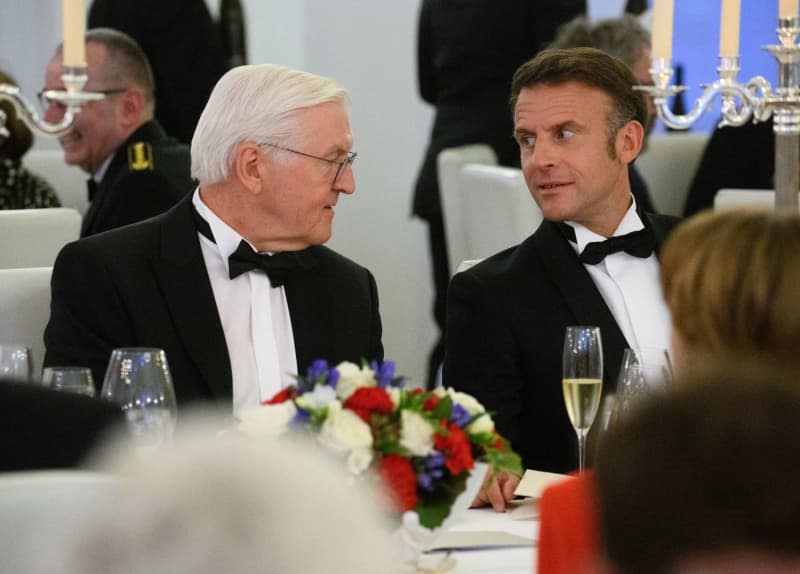 German President Frank-Walter Steinmeier (L) talks with French President Emmanuel Macron at the state banquet in honor of the Macron and his wife at Bellevue Palace. Bernd von Jutrczenka/dpa