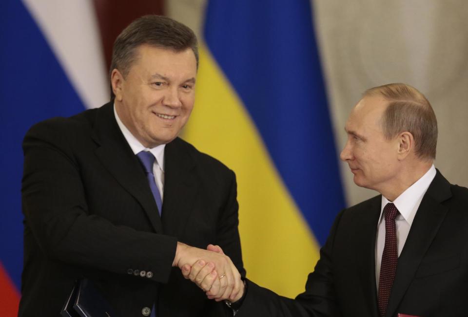 FILE - In this Tuesday, Dec. 17, 2013 file photo, Russian President Vladimir Putin, right, and his Ukrainian counterpart Viktor Yanukovych shake hands after signing an agreement during their talks in Moscow. Moscow on Wednesday granted Ukrainian President Viktor Yanukovych protection "on the territory of Russia," shortly after the fugitive leader sought help from the Kremlin, according to an official quoted by Russian news agencies. (AP Photo/Ivan Sekretarev, File)