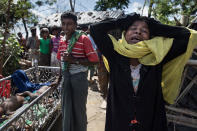 <p>Madia Khatun, a relative, grieves next to the bodies of 5 children, after an overcrowded boat carrying Rohingya fleeing Myanmar capsized overnight killed around 12 people including five children on October 9, on Shah Porir Dwip Island, Cox’s Bazar, Bangladesh. (Photograph by Paula Bronstein/Getty Images) </p>