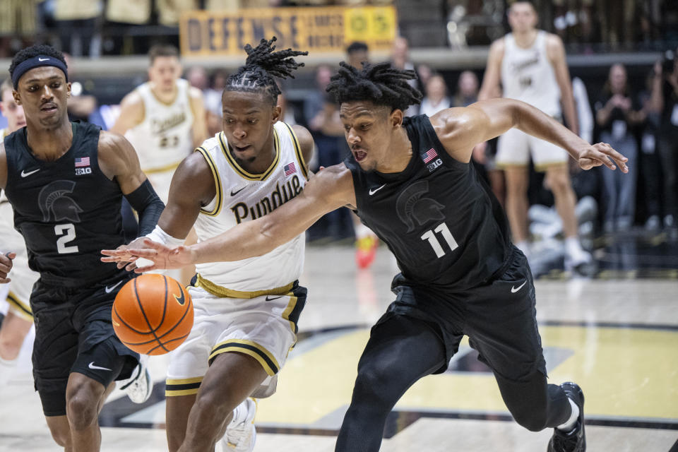 Michigan State guard A.J. Hoggard (11) attempts to strip the ball away from Purdue guard Lance Jones during the second half of an NCAA college basketball game Saturday, March 2, 2024, in West Lafayette, Ind. (AP Photo/Doug McSchooler)