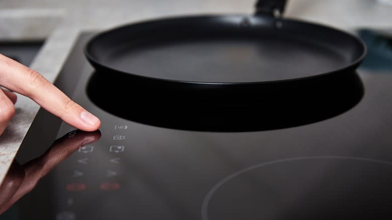 Person turning on induction hob
