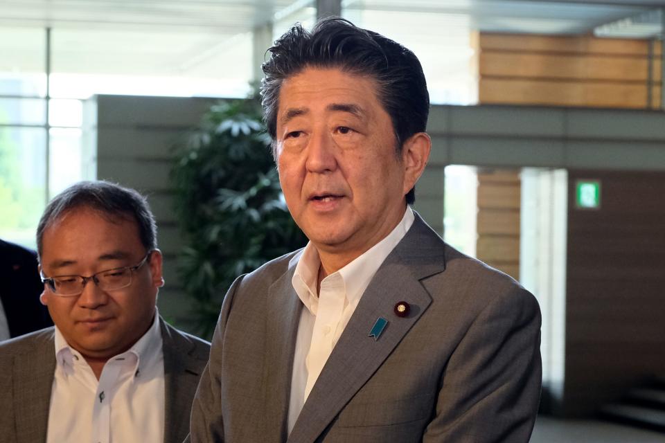 Japan's Prime Minister Shinzo Abe (R) answers questions from reporters upon his arrival at the prime minister's office in Tokyo on July 31, 2019, in response to reports North Korea fired two ballistic missiles earlier in the morning. - Pyongyang fired two ballistic missiles on July 31, Seoul said, days after a similar launch that the nuclear-armed North described as a warning to the South over planned joint military drills with the United States. (Photo by Kazuhiro NOGI / AFP)        (Photo credit should read KAZUHIRO NOGI/AFP/Getty Images)