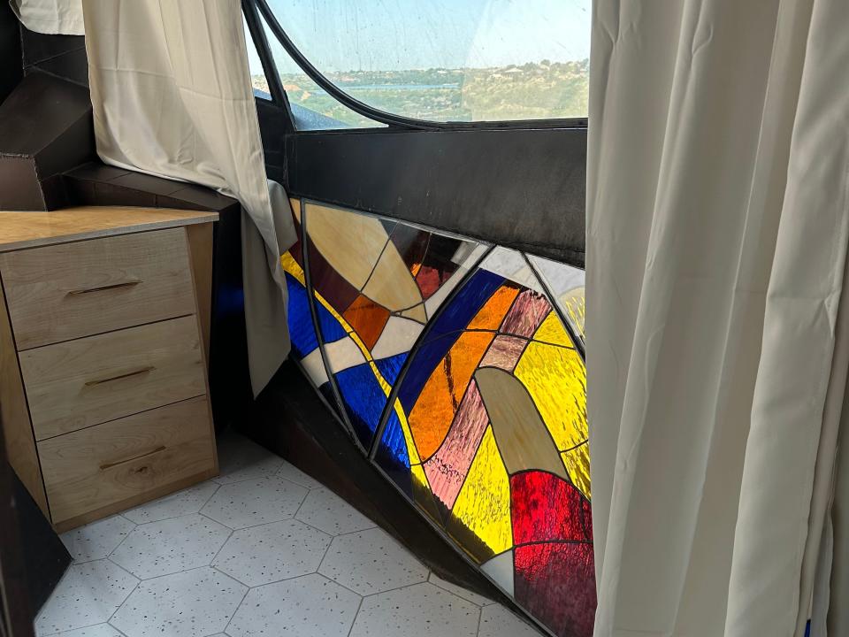 Stained-glass wall below a window in a bedroom