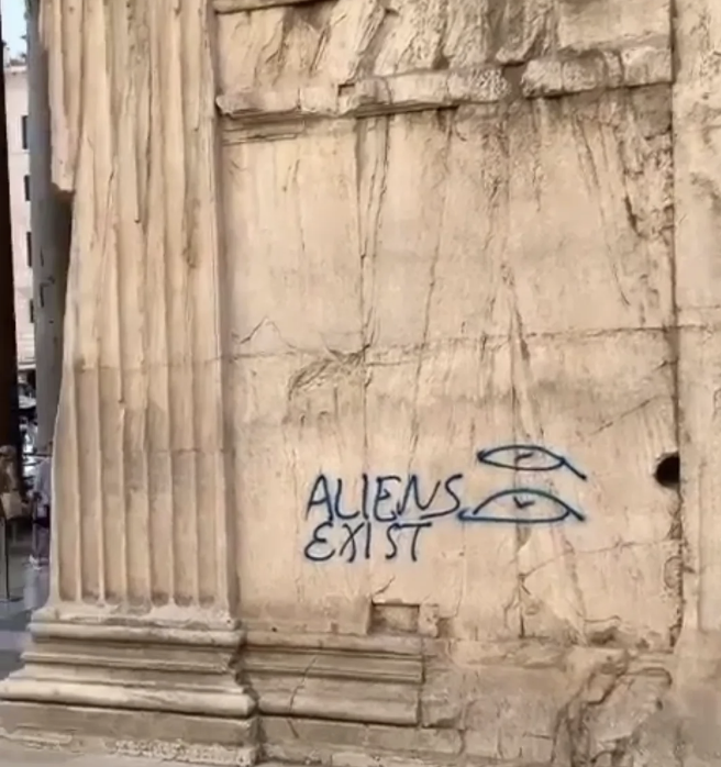 Graffiti on an ancient stone building reads 