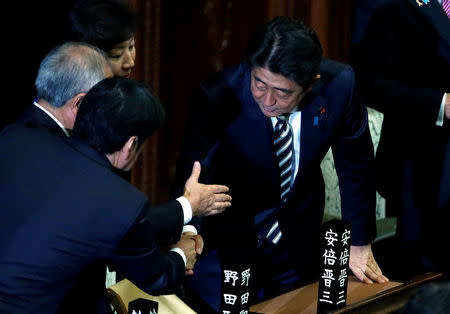 Japan's Prime Minister Shinzo Abe (R) shakes hands with his ruling Liberal Democratic Party lawmakers after he is re-elected as prime minister at the Lower House of Parliament in Tokyo, Japan, November 1, 2017. REUTERS/Toru Hanai