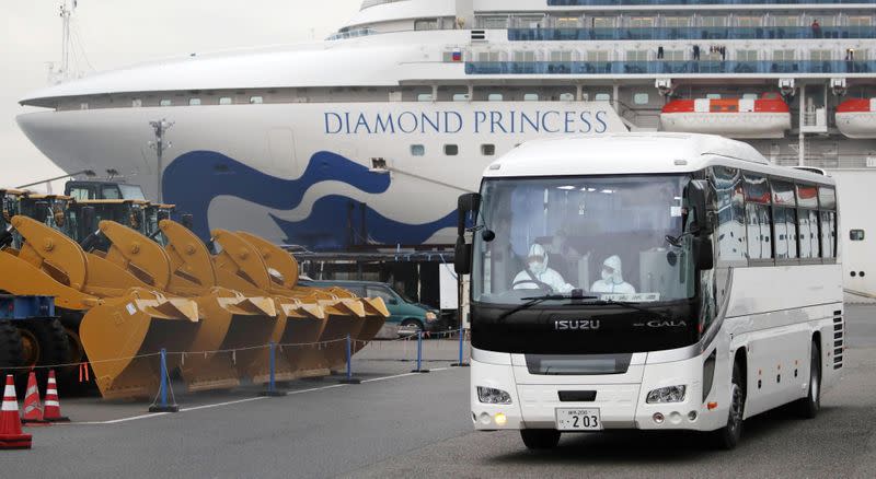 A driver wearing protective suits is seen inside a bus which believed to carry elderly passengers of the cruise ship Diamond Princess, where dozens of passengers were tested positive for coronavirus, in Yokohama