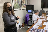 Rachel Rodriguez, left, the elections management specialist for Dane County, Wis., looks over a table of ballots being tested before being sent to more than 200 voting locations across the state's second-largest county on Wednesday, Sept. 14, 2022, in Madison, Wis. Her office is among those that have been hammered with requests by what appear to be coordinated campaigns by groups who reject the results of the 2020 presidential election. (AP Photo/Scott Bauer)