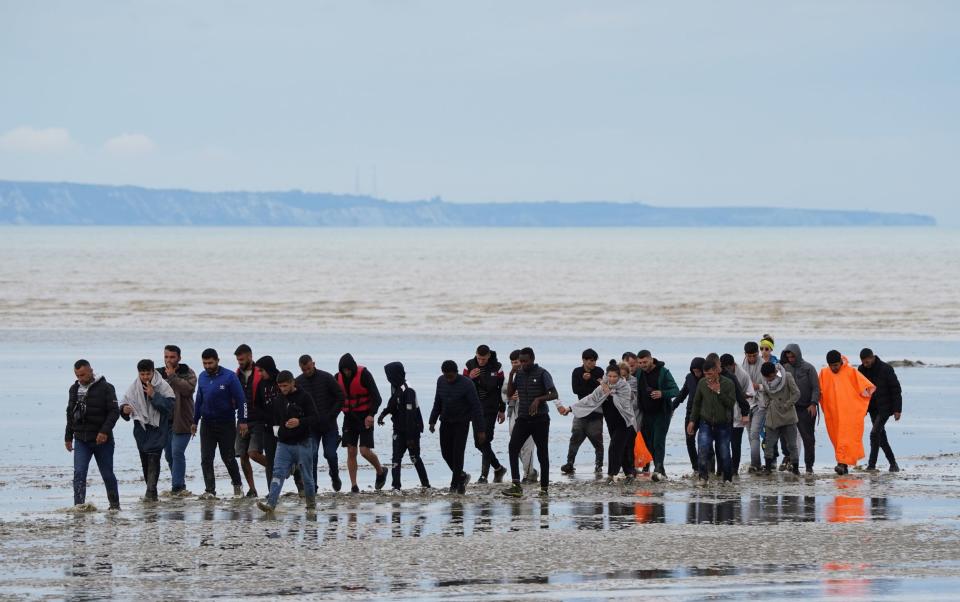 Migrants walk ashore in Dover, Kent, on Thursday after arriving into the UK on small boats across the Channel - Gareth Fuller 