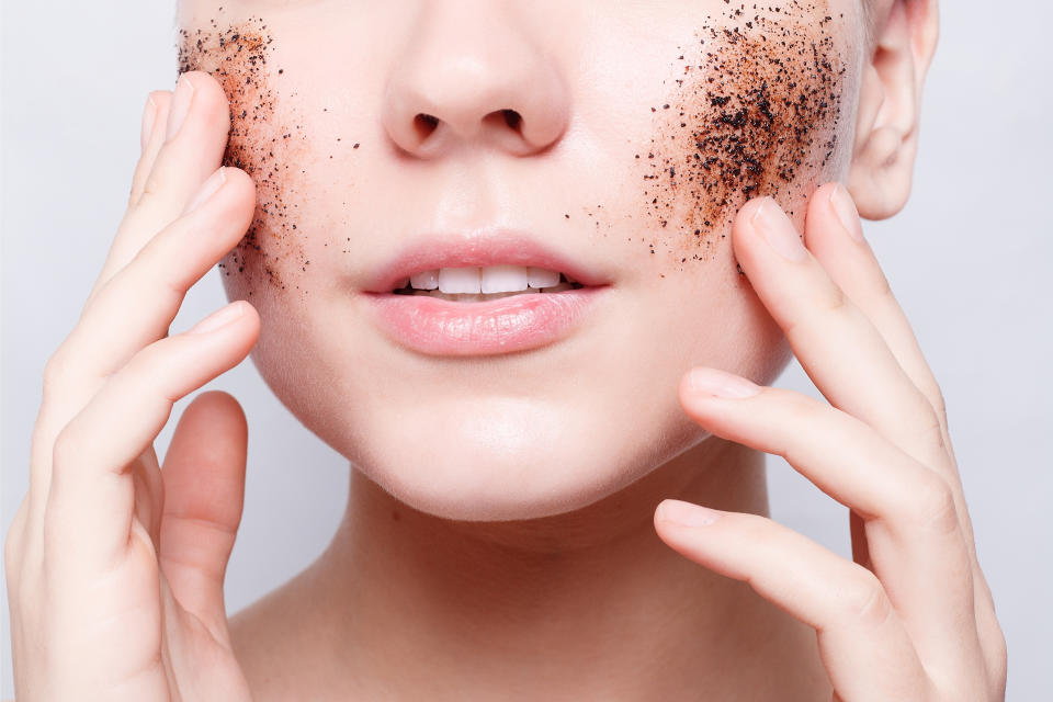 health, people, Skin Care, youth and beauty concept - Smiling woman with short hair, bald cleans the skin coffee skrub, studio shot, close-up portrait. Clean Fresh Skin close up. Spa Woman Smiling