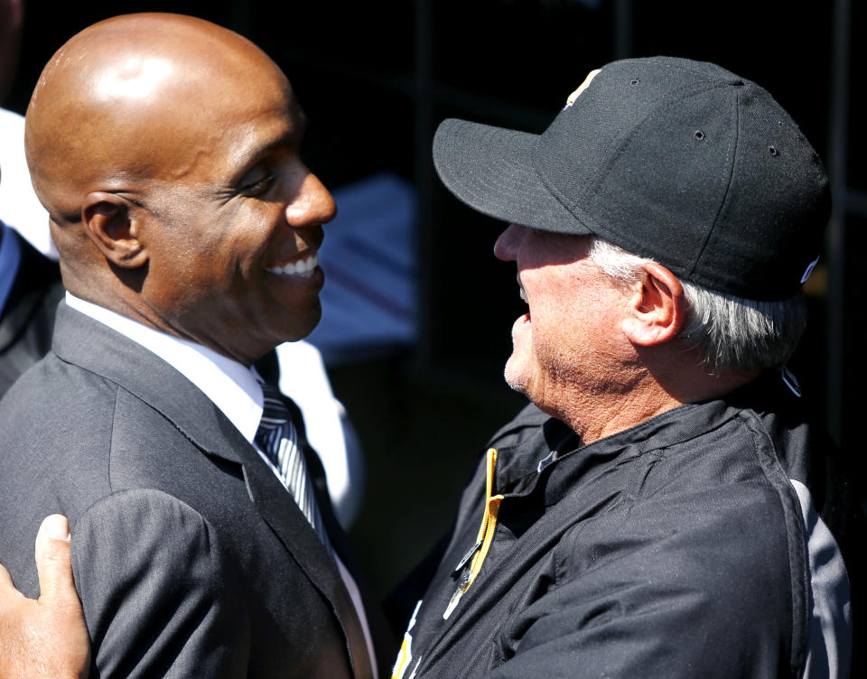 Former Pittsburgh Pirates outfielder Barry Bonds, left, is greeted by current manager Clint Hurdle during opening day ceremonies before a baseball game between the Pirates and the Chicago Cubs on Monday, March 31, 2014, in Pittsburgh. (AP Photo/Keith Srakocic)