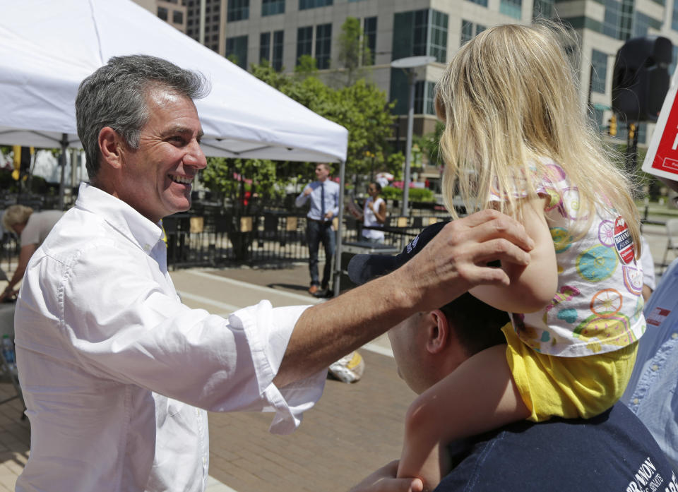 North Carolina Republican Senate hopeful Greg Brannon, left, greets Adam Love, right, and his daughter Gwendolyn Love, 2, during a campaign event in Charlotte, N.C., Monday, May 5, 2014. The struggle for control of the Republican Party gets an early voter test in North Carolina, where GOP leaders Mitt Romney and Rand Paul push candidates competing for the right challenge Democratic Sen. Kay Hagan in the November midterm elections. (AP Photo/Chuck Burton)