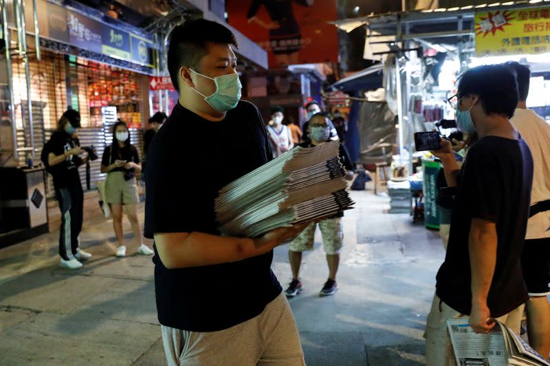 A supporter of Apple Daily newspaper, buys a bundle of Apple Daily newspapers for his friends and colleagues to support media mogul Jimmy Lai Chee-ying, in Hong Kong
