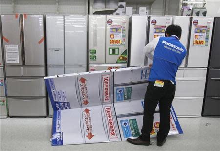 An employee folds a mock model of Panasonic Corp's refrigerator at an electronics store in Tokyo October 24, 2012. REUTERS/Yuriko Nakao