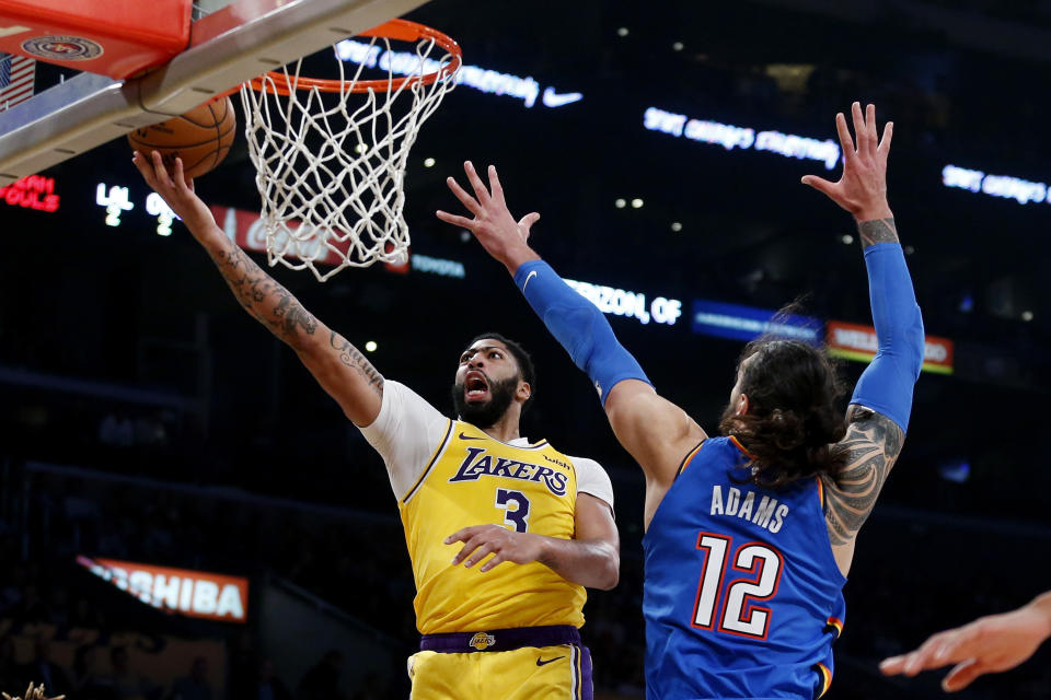 Los Angeles Lakers' Anthony Davis (3) goes to the basket as Oklahoma City Thunder's Steven Adams (12) dfends during the first half of an NBA basketball game Tuesday, Nov. 19, 2019, in Los Angeles. (AP Photo/Ringo H.W. Chiu)