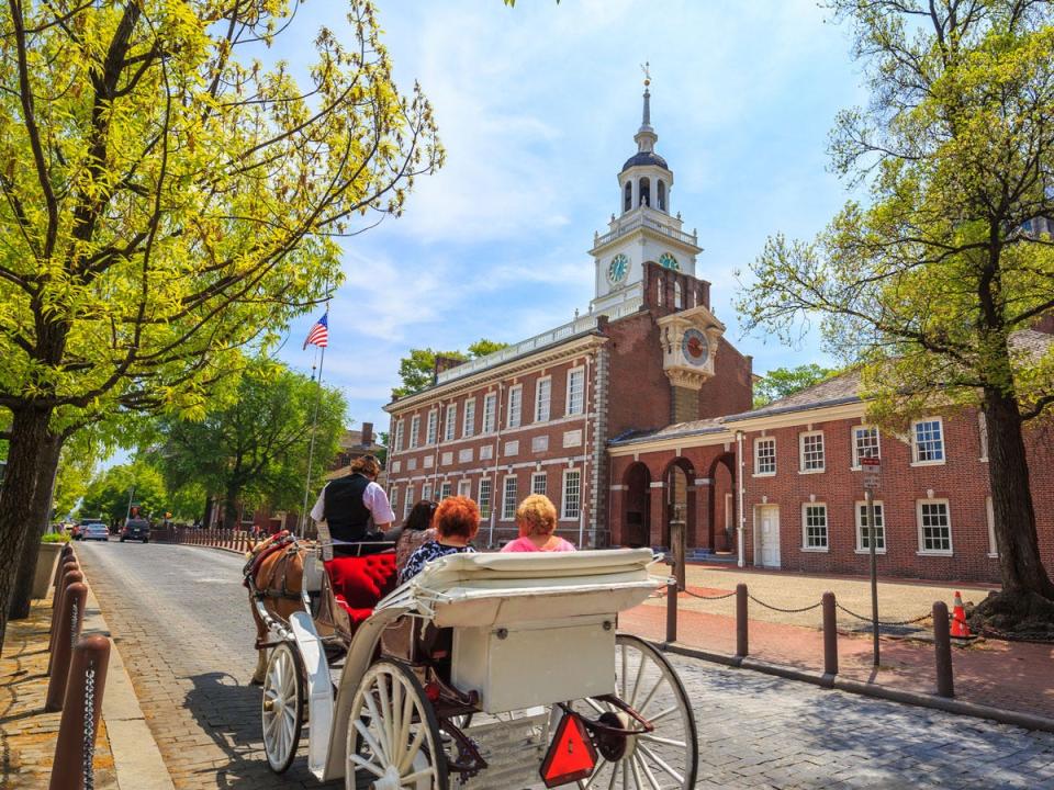 Visitors ride in a carriage past Independence Hall in Philadelphia, where the Declaration of Independence was signed.