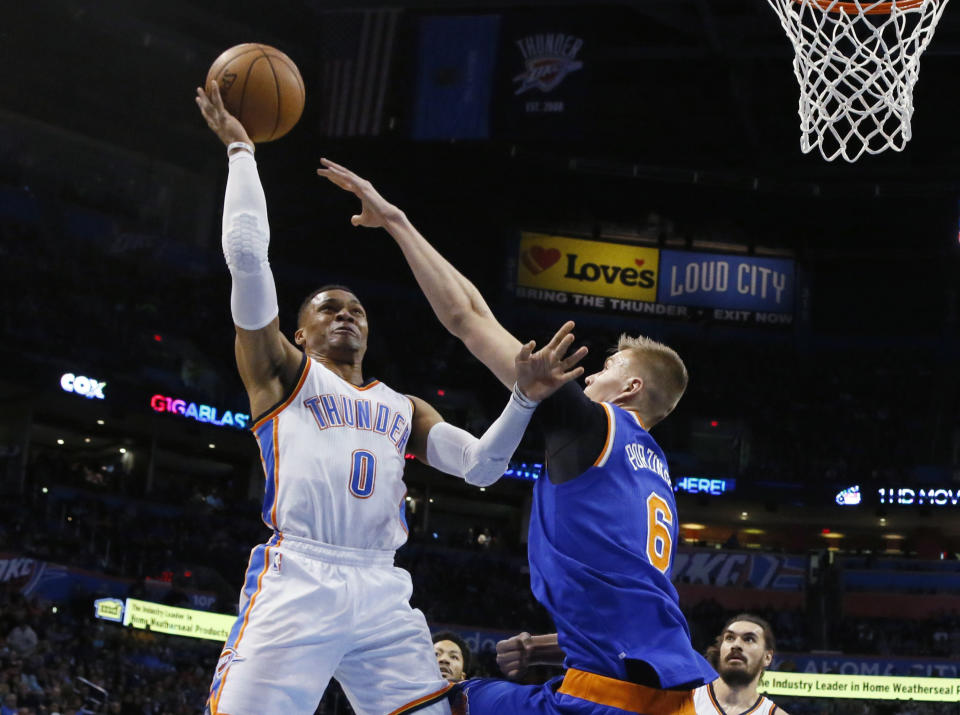 Oklahoma City Thunder guard Russell Westbrook (0) shoots over New York Knicks forward Kristaps Porzingis (6) during the first quarter of an NBA basketball game in Oklahoma City, Wednesday, Feb. 15, 2017. (AP Photo/Sue Ogrocki)