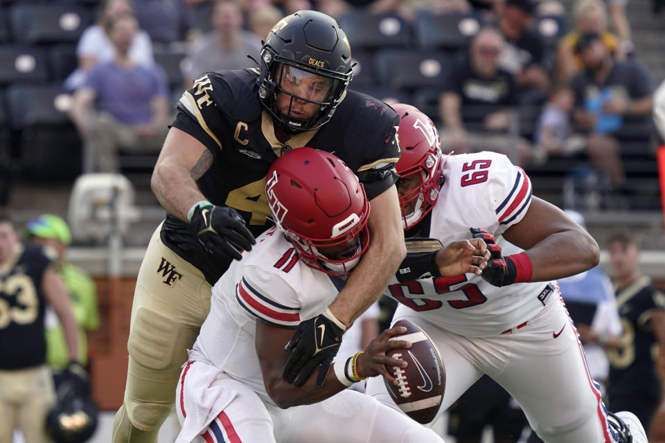 Liberty quarterback Johnathan Bennett (11) is sacked by Wake Forest defensive lineman Rondell Bothroyd (40) during the first half of an NCAA college football game in Winston-Salem, N.C., Saturday, Sept. 17, 2022. (AP Photo/Chuck Burton)