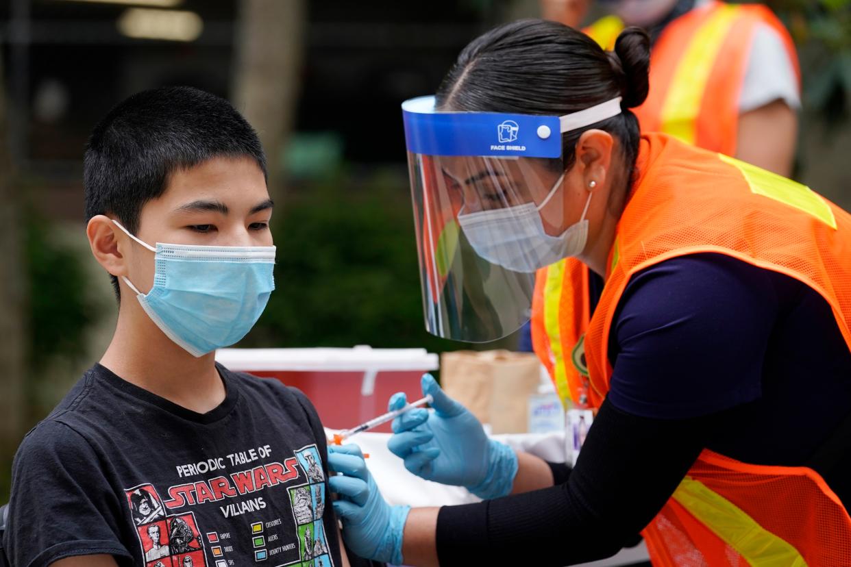 Noah Chen, 13, gets a shot of the Pfizer COVID-19 vaccine at the First Baptist Church of Pasadena, Friday, May 14, 2021, in Pasadena, Calif.