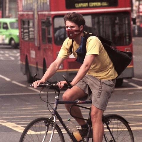 A man on a bike wearing a mask  - Credit: EPA