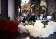 Florist Maria Moskalyk sorts through a newly arrived order of roses in the Giraffe Flowers florist shop in Manchester