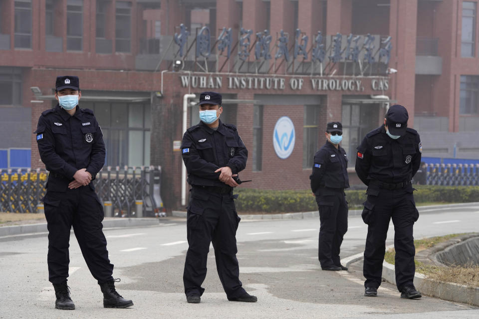 Security personnel wearing masks stand near the entrance of the Wuhan Institute of Virology in Wuhan, China. 