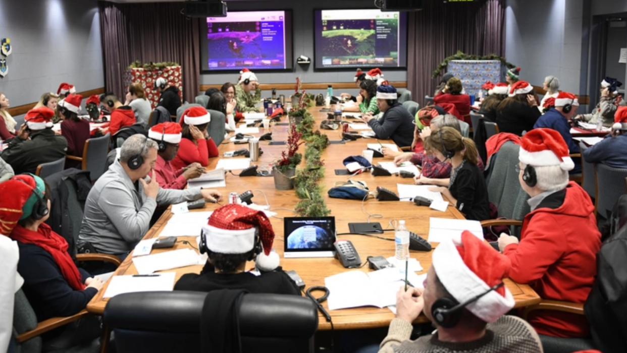 Volunteers around a table track Santa on phone calls