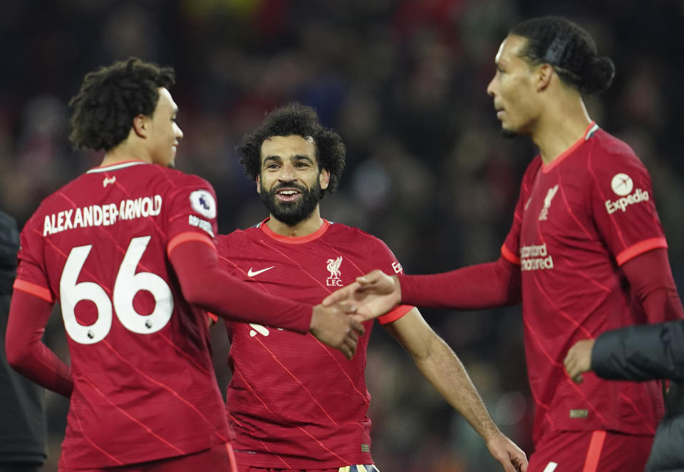 Liverpool's Trent Alexander-Arnold, left, Liverpool's Mohamed Salah, centre, Liverpool's Virgil van Dijk celebrate at the end of the English Premier League soccer match between Liverpool and Arsenal at Anfield Stadium, Liverpool, England, Saturday, Nov. 20, 2021. (AP Photo/Jon Super)