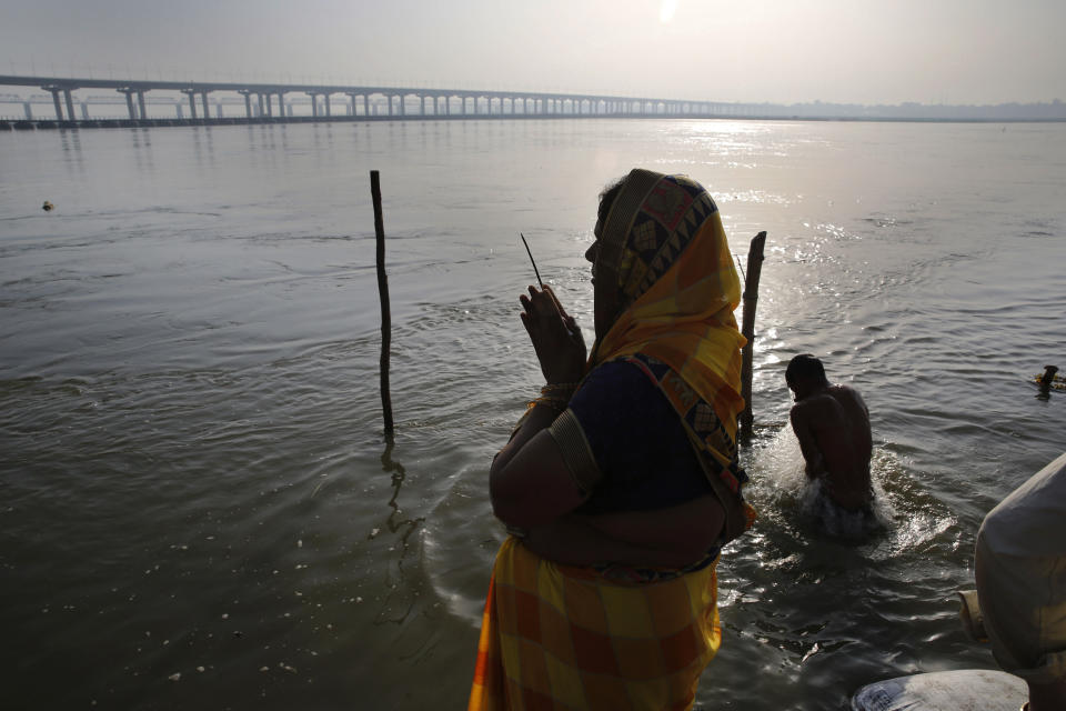 FILE - In this Wednesday, April 1, 2020 file photo, a Hindu devotee performs rituals on Ashtami, eighth day of Navratri festival at Sangam, the confluence of the rivers Ganges and Yamuna in Prayagraj, India. Hindus celebrate Navaratri, or the festival of nine nights, with three days each devoted to the worship of Durga, the goddess of valor, Lakshmi, the goddess of wealth, and Saraswati, the goddess of knowledge. (AP Photo/Rajesh Kumar Singh)