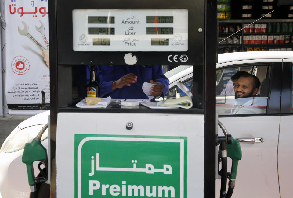 A worker writes a receipt at a gas station in Jiddah, Saudi Arabia, Monday, Sept. 16, 2019. Global energy prices spiked on Monday after a weekend attack on key oil facilities in Saudi Arabia caused the worst disruption to world supplies on record, an assault for which President Donald Trump warned that the U.S. was "locked and loaded" to respond. (AP Photo/Amr Nabil)