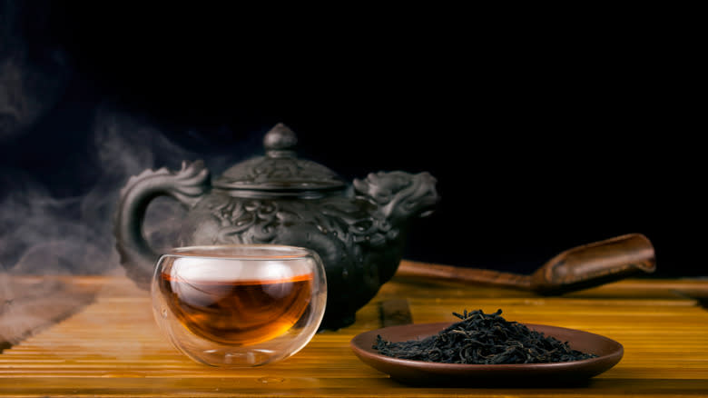 Cup of tea next to plate of loose leaf tea