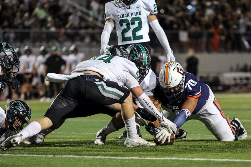 Cedar Park defenders try to pounce on a loose ball. Cedar Park recovered four fumbles and frustrated the Grizzlies' rushing attack in a 21-10 district victory Friday at Bible Stadium.