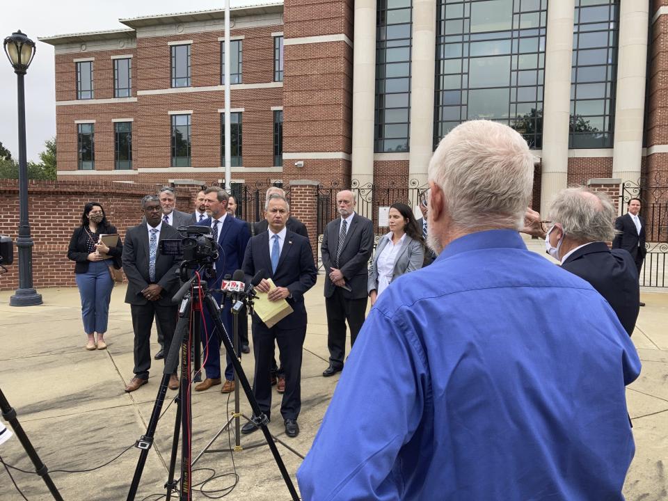 Activist Tom Clements, right, asks federal prosecutors and investigators questions during a news conference Thursday, Oct. 7, in Columbia, S.C. An executive who spent billions of dollars on two South Carolina nuclear plants that never generated a watt of power, lying and deceiving regulators about their progress, is ready to go to prison. Former SCANA Corp. CEO Kevin Marsh has agreed with prosecutors that he should spend two years in prison. He goes before a federal judge Thursday who will decide whether to accept that deal. (AP Photo/Jeffrey Collins)