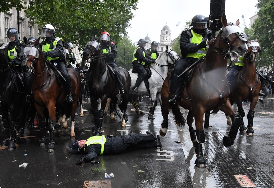 TOPSHOT - A mounted police officer lays on the road after being unseated from their horse, during a demonstration on Whitehall, near the entrance to Downing Street in central London on June 6, 2020, to show solidarity with the Black Lives Matter movement in the wake of the killing of George Floyd, an unarmed black man who died after a police officer knelt on his neck in Minneapolis. - The United States braced Friday for massive weekend protests against racism and police brutality, as outrage soared over the latest law enforcement abuses against demonstrators that were caught on camera. With protests over last week's police killing of George Floyd, an unarmed black man, surging into a second weekend, President Donald Trump sparked fresh controversy by saying it was a "great day" for Floyd. (Photo by DANIEL LEAL-OLIVAS / AFP) (Photo by DANIEL LEAL-OLIVAS/AFP via Getty Images)