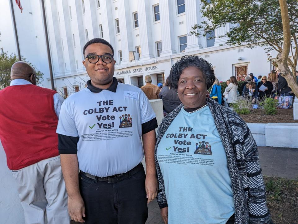 Erech Brown, left, and his mother, Gwendolyn Brown, show off the shirts he designed in front of the Alabama State House on March 15.