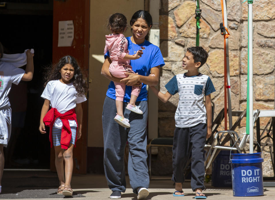 Venezuelan migrant Juaniela Castillo steps out of the shelter at St. Francis Xavier Church with her three children Victoria, 3, Cecilia, 7 and Carmelo, 8, in El Paso, Texas, Thursday, May 11, 2023. As confusion explodes in El Paso, one of the busiest illegal crossings points for migrants seeking to flee poverty and political strife, faith leaders continue to provide shelter, legal advice and prayer. (AP Photo/Andres Leighton)