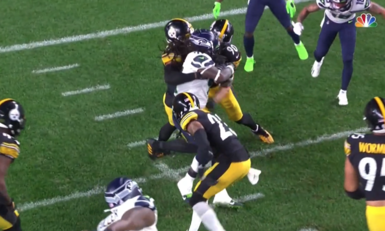 Pittsburgh Steelers' T.J. Watt punches at Alex Collins of the Seahawks.