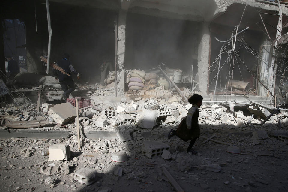 A girl runs rubble after an airstrike in Douma, Syria